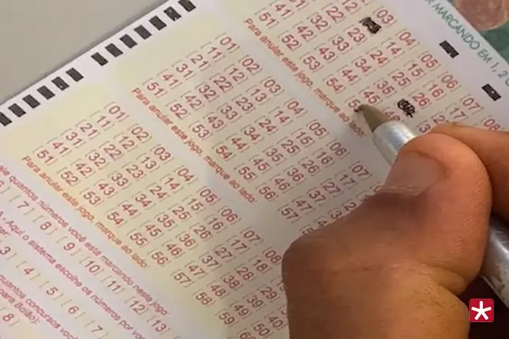 mão segurando caneta, marcando os números no cartão da loteria